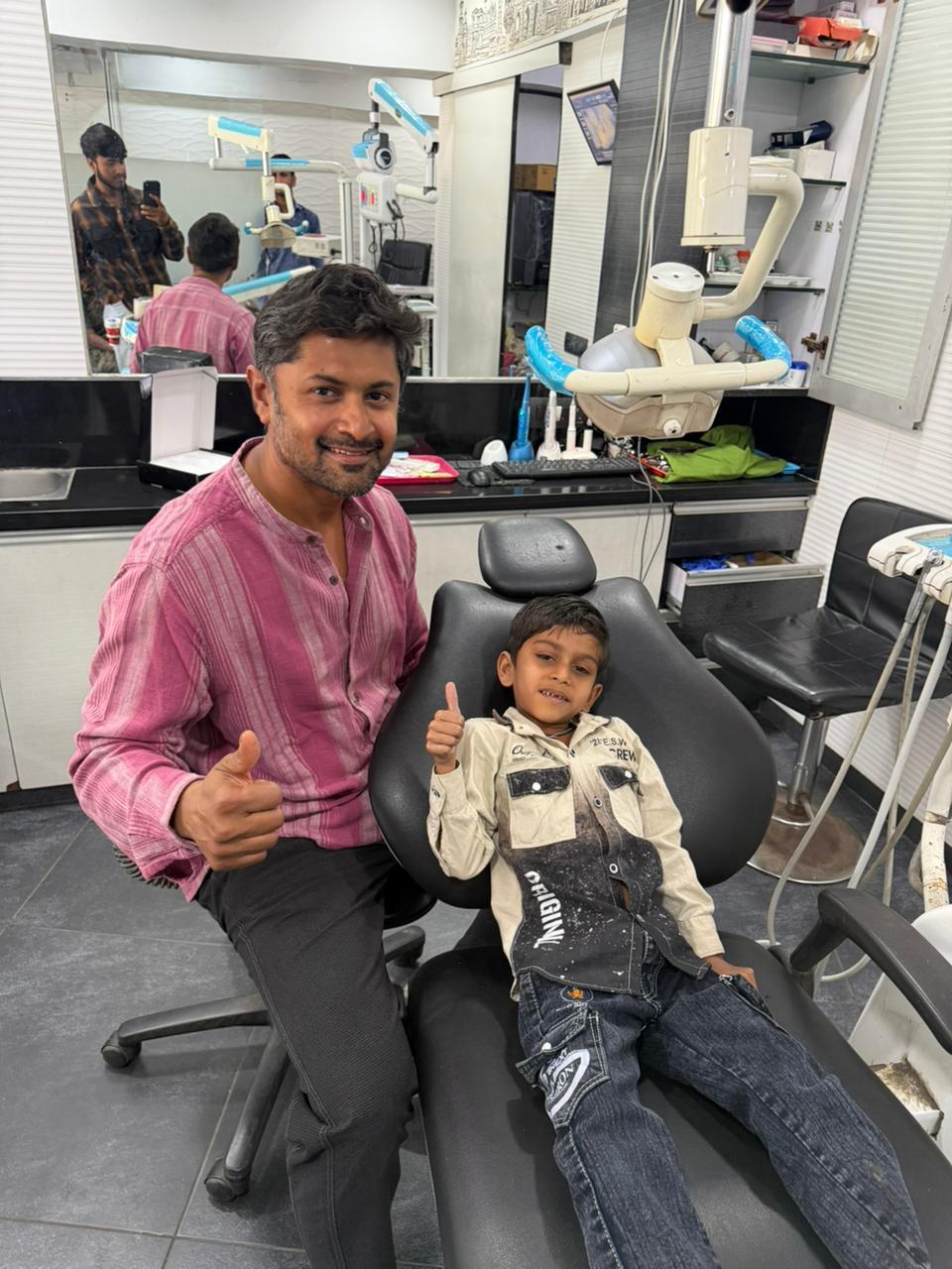 Dr. Varun with a happy child patient in the dental chair at Dr. Varun's Dental Clinic, Ahmedabad